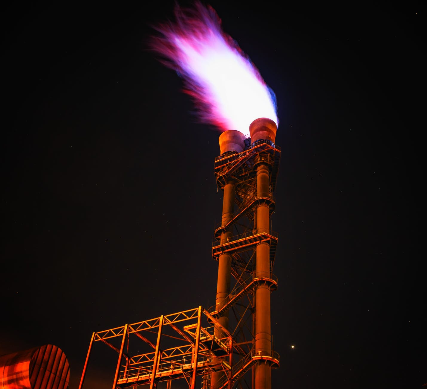 low angle view of illuminated tower against sky at night - The Bright Side of using Fossil Fuel in Modern Times